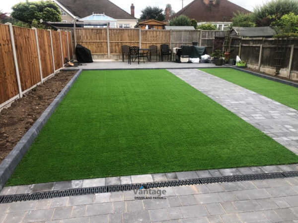 Tegula Paved Driveway and Patio with Flower Beds and Artificial Lawn in Chelmsford