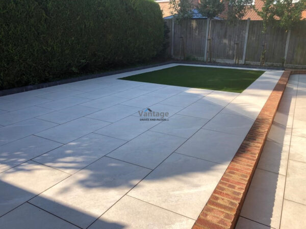 Porcelain Tiled Patio with Brickwall and Artificial Lawn in Chelmsford