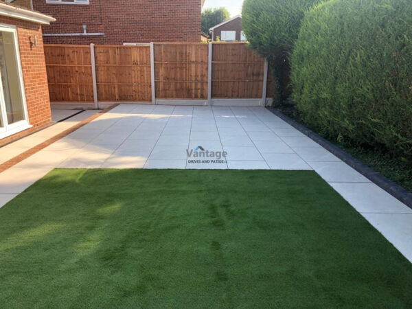 Porcelain Tiled Patio with Brickwall and Artificial Lawn in Chelmsford
