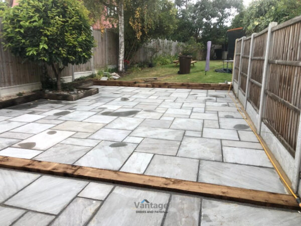 Tiered Sandstone Patio with Retaining Sleeper Walls in Chelmsford