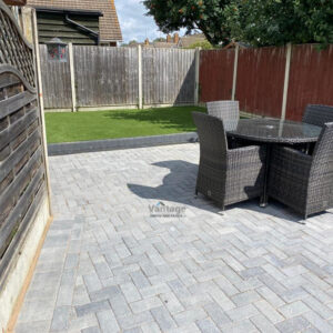 Charcoal Block Paved Patio with Raised Artificial Lawn in Witham,…